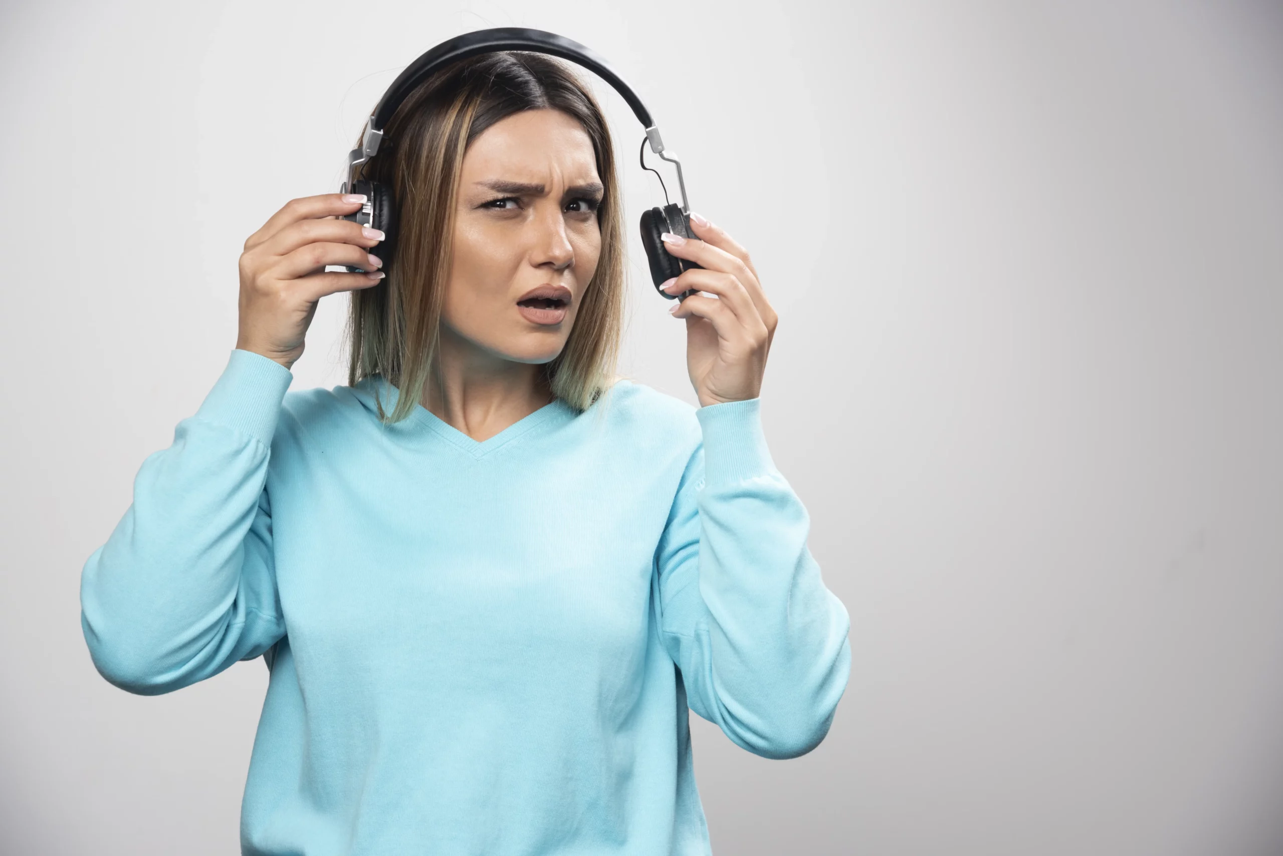 Mulher com fones de ouvido danificados