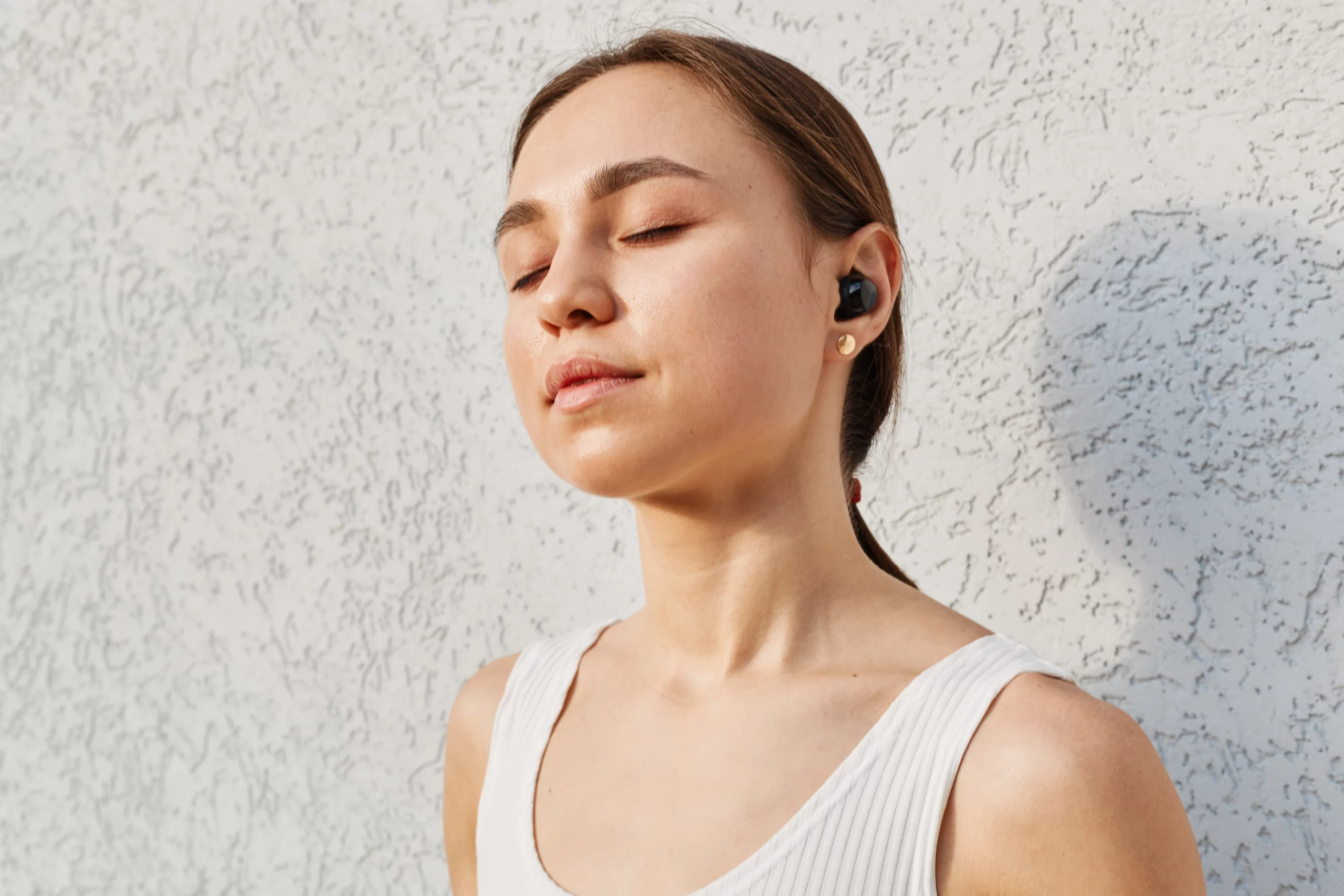 Jovem com os olhos fechados ouvindo música