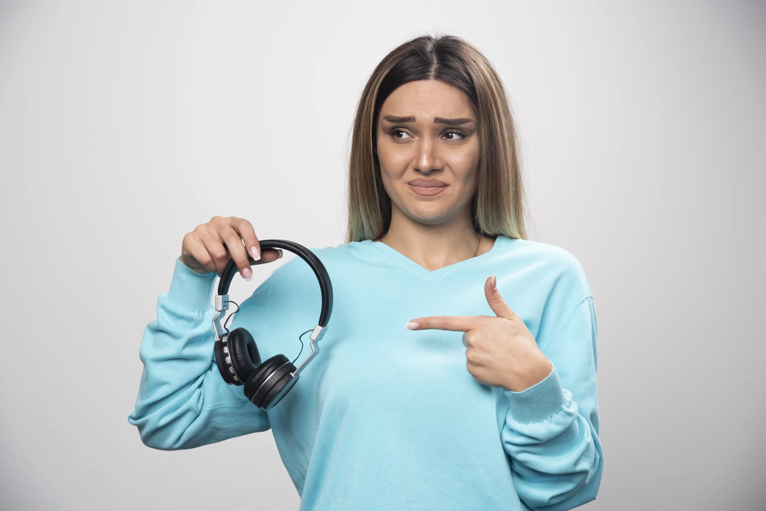 Menina indicando que o fone está com defeito